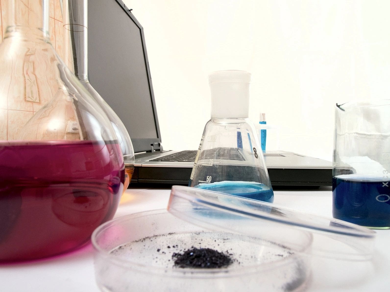 A table with some beakers and a laptop